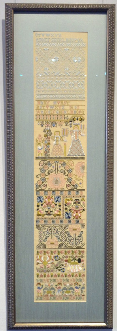 Antique embroidery sampler that has been matted and framed.