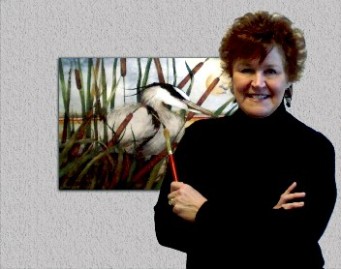 Photo of the artist standing in front of a painting of a heron.