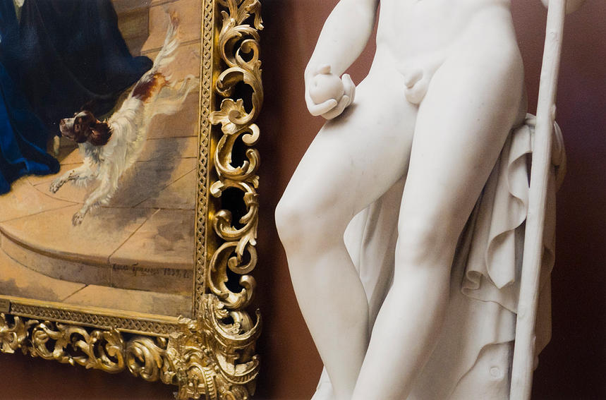 Detail of corner of framed painting and lower half of nude male statue