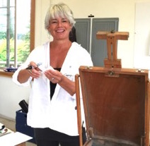 Artist Carrie Moore in front of an easel in her studio