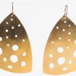 Gold earrings in a triangle shape with open circles across them