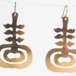 Gold earrings that look like a stylized plant seedling